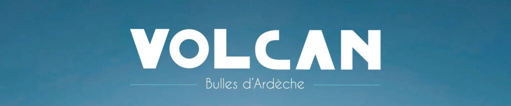 Image de couverture publicitaire pour la marque "Volcan - Bulles d'Ardèche". Le visuel présente un fond de ciel bleu azur dégradé avec un soleil lumineux en partie basse. Le texte est centré en lettres blanches, indiquant en français et en anglais : "EAU MINÉRALE NATURELLEMENT GAZEUSE AU CŒUR DU PARC NATUREL DES MONTS D’ARDÈCHE". Dans le coin inférieur droit, on aperçoit le goulot d'une bouteille en verre transparent surmontée d'une capsule bleu turquoise.