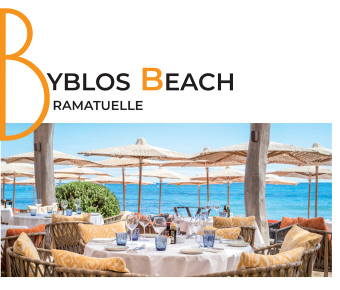 Reportage exclusif réalisé pour l'édition de Juin 2026 de THE Magazine au restaurant de plage Byblos Beach à Ramatuelle. Vue d'une élégante table ronde dressée face à la mer Méditerranée, sous les parasols emblématiques de l'établissement. Crédit photo d'origine : Alexandre Chaplier.