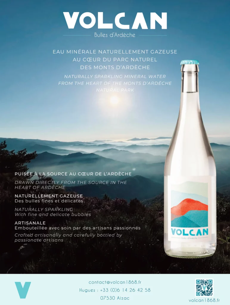 Image de couverture publicitaire pour la marque "Volcan - Bulles d'Ardèche". Le visuel présente un fond de ciel bleu azur dégradé avec un soleil lumineux en partie basse. Le texte est centré en lettres blanches, indiquant en français et en anglais : "EAU MINÉRALE NATURELLEMENT GAZEUSE AU CŒUR DU PARC NATUREL DES MONTS D’ARDÈCHE". Dans le coin inférieur droit, on aperçoit le goulot d'une bouteille en verre transparent surmontée d'une capsule bleu turquoise.